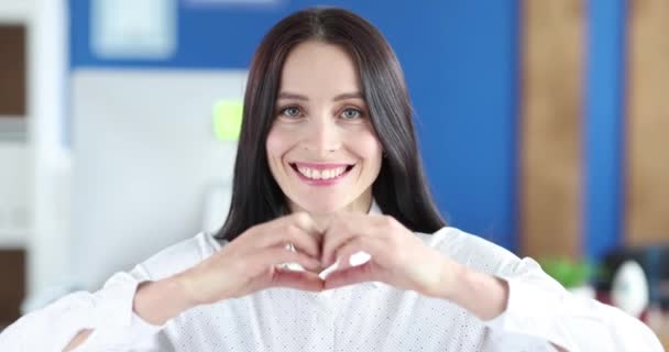 미소짓는 여자는 손으로 심장 제스처를 한다 — 비디오