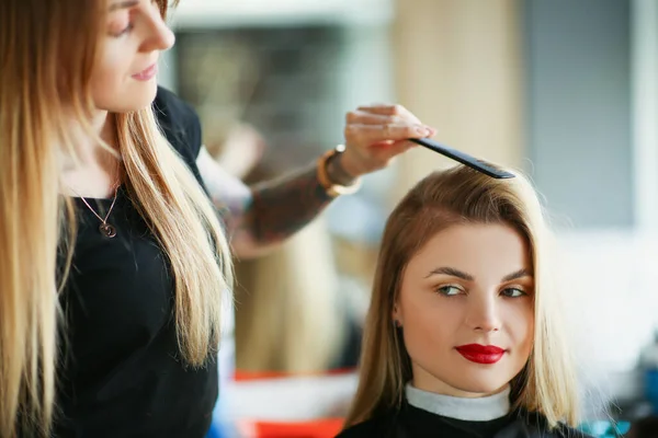 Frisör använder kam för att borsta klienter hår, kvinna på möte i salong — Stockfoto