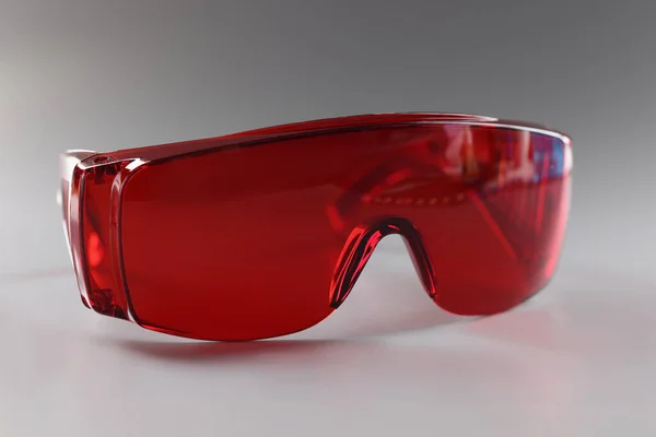 Rode plastic veiligheidsbril, beschermende werkkleding voor menselijke ogen — Stockfoto