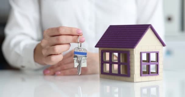 Realtor toont model van huis en sleutels — Stockvideo