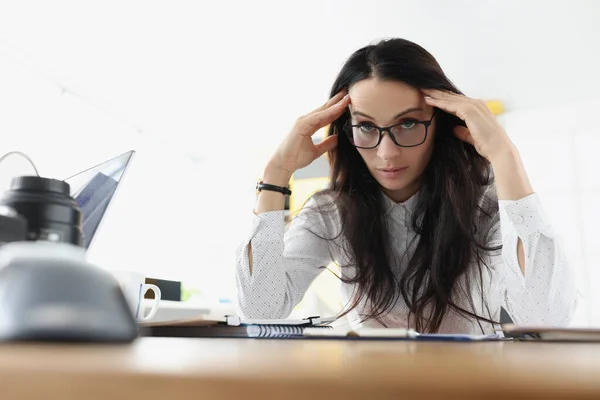 Женщина сидит за столом в стрессе на работе, крупным планом — стоковое фото