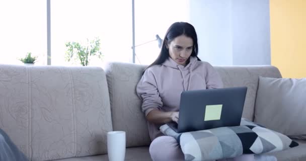 Freelancer femenina enfocada trabajando en casa en laptop — Vídeos de Stock