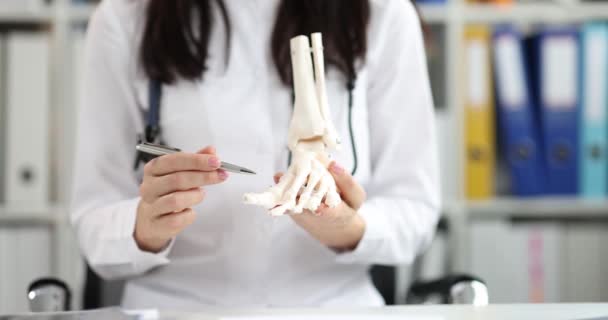 Médico detém modelo de ossos da perna humana — Vídeo de Stock