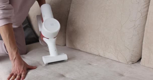 Beskuren utsikt över hemmafru rengöring soffa med dammsugare — Stockvideo