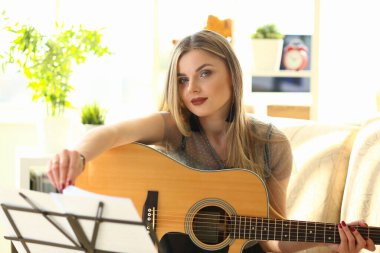 Genç kadın gitar çalmayı öğreniyor.