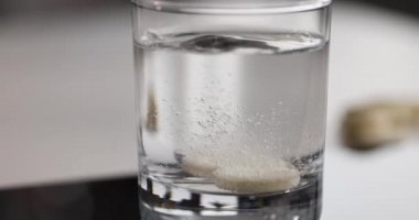 Bir bardak suda çözünür tıbbi tablet.