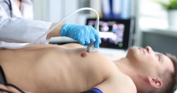 Dokter voert medisch onderzoek van echografie van het hart van de mens — Stockvideo