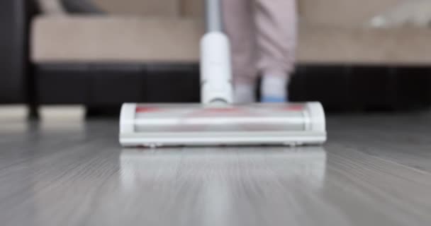 Frau saugt Boden mit Akku-Staubsauger in modernem Wohnzimmer — Stockvideo