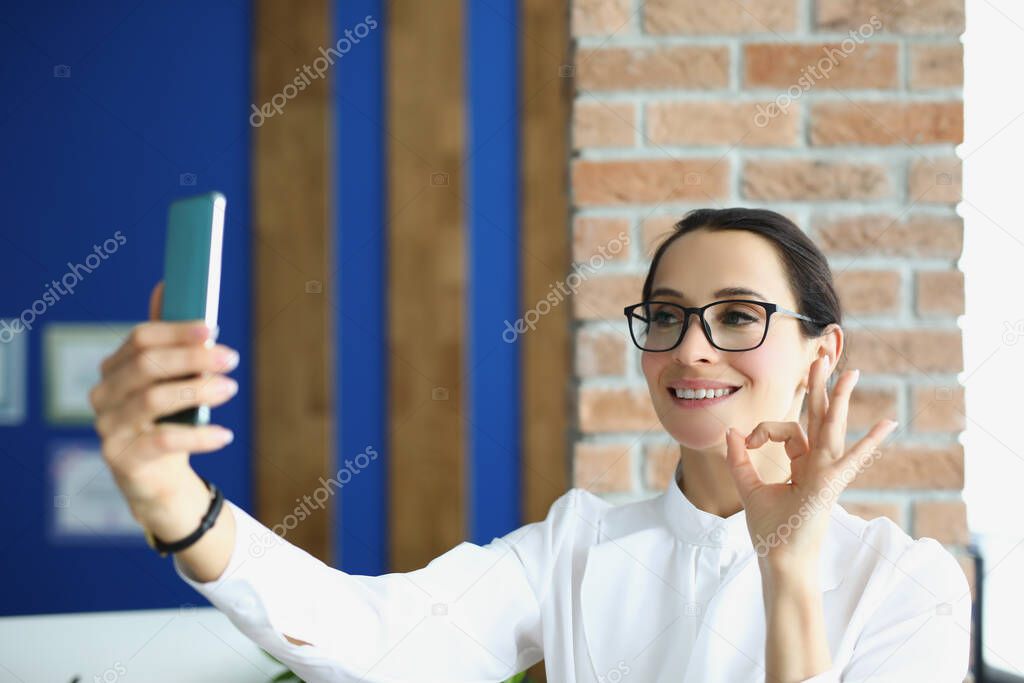 A woman speaks by video call on a smartphone