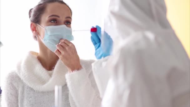 Женщина проходит ПЦР в кабинете врача во время коронавирусной эпидемии крупным планом — стоковое видео
