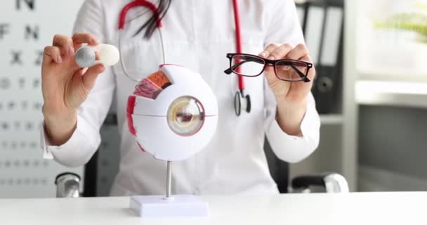 Ophtalmologiste tient des lunettes et des lentilles de contact dans les mains gros plan — Video