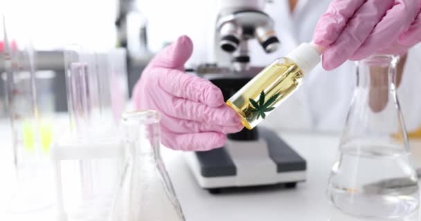 Person hält Glas Cannabisöl in Labornahaufnahme — Stockvideo