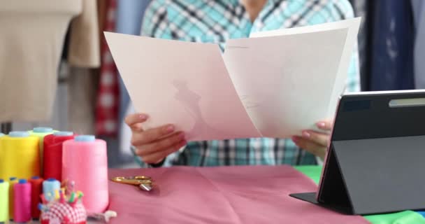 Elegante diseñadora femenina que mira bocetos en la oficina del estudio de moda — Vídeos de Stock