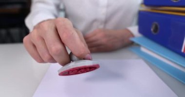 Masa örtüsüne kırmızı etiket yapıştıran kişi