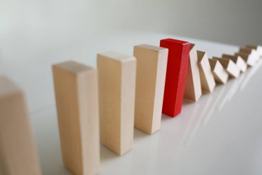 Bir kırmızı tahta blok diğerlerinin domino taşları gibi düşmesini engeller.
