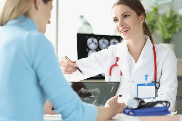 Femme médecin expliquer le résultat de l'échographie de rayons X à la patiente — Photo