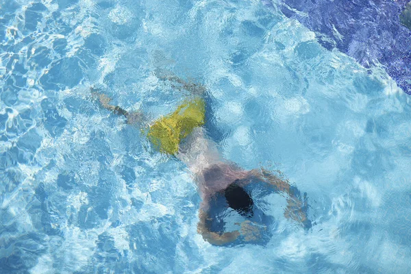 Άντρας στην πισίνα επιπλέει στο νερό στην κοιλιά, καταδύσεις στο βάθος — Φωτογραφία Αρχείου