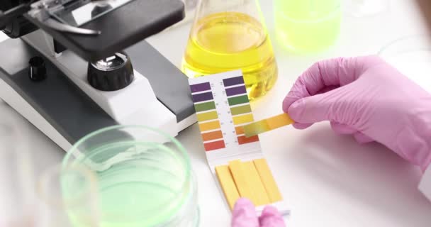 Chemist in lab checking with ph strips closeup — Stock Video