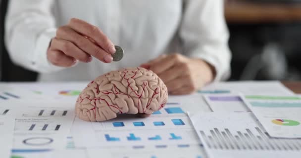 Mujer gerente poniendo moneda en el cerebro humano y mostrando gesto pulgar hasta primer plano 4k película cámara lenta — Vídeo de stock