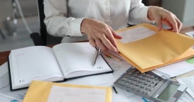 Ofisteki masada posta mektuplarını sıralayan kadın sekreter 4K film kapanışı.