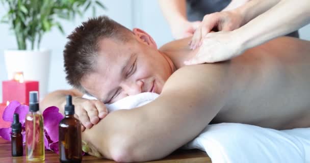 Las mujeres que dan masaje de espalda al hombre en el spa 4k película cámara lenta — Vídeos de Stock
