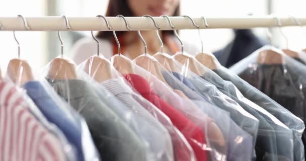 Woman sorting clothes in plastic bags on hangers in dry cleaning closeup 4k movie slow motion — Stock Video