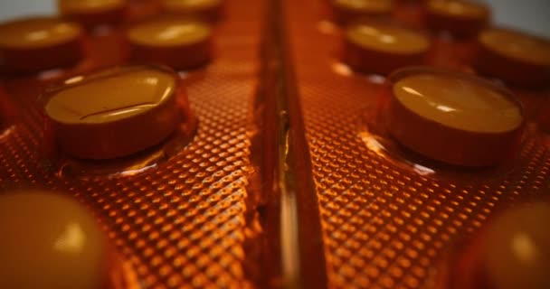 Pílulas médicas redondas em laranja blister closeup — Vídeo de Stock