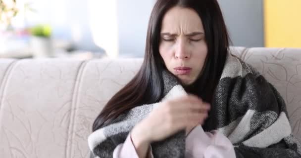 Młoda kobieta kaszle pod kołdrą i wyjmuje termometr ze swojego filmu pod pachą 4k — Wideo stockowe