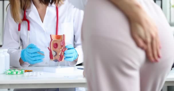 Lékař ukazuje na anatomický model lidského konečníku problémy trávení nemocné ženy detailní up 4k film — Stock video