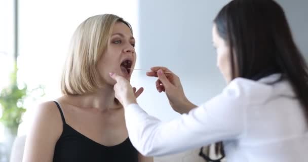 Médecin examinant la gorge de la patiente à la maison film 4k — Video