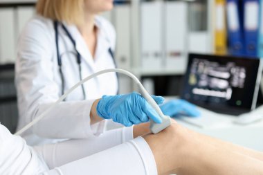 Doktor klinikteki hastanın diz eklemini ultrasonla muayene ediyor.