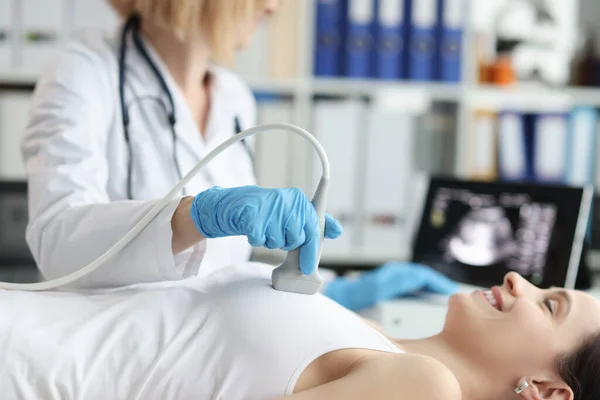 医師は、診療所で患者の乳房の超音波検査を行う — ストック写真