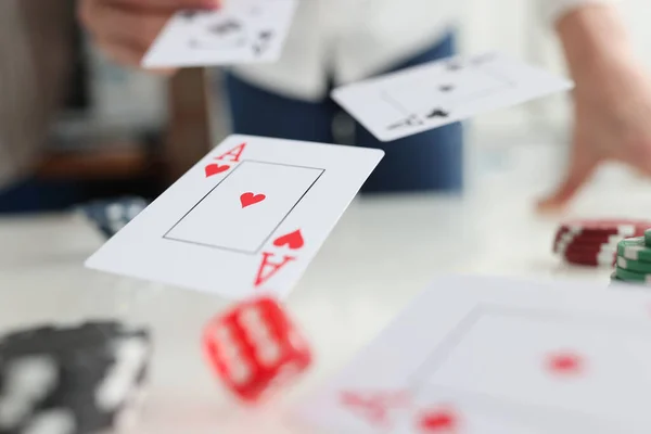 Jugar a las cartas ases y dados volando sobre la mesa de juego en primer plano del casino — Foto de Stock