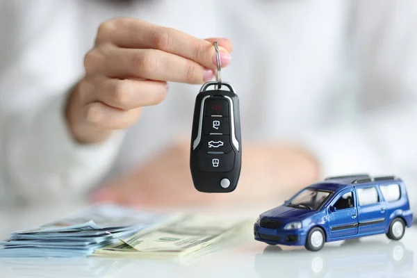 Concesionario con llaves delante de coche de juguete y primer plano de dinero — Foto de Stock