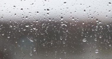 Koyu şeffaf camlara damlayan yağmur damlaları yakın plan 4K film