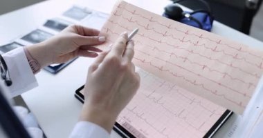 Doktor kardiyolog tablet üzerindeki elektrokardiyogramı yakından inceler.
