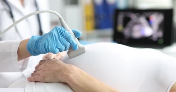 Médico haciendo ultrasonido del feto a la paciente embarazada en la clínica de primer plano 4k película cámara lenta — Vídeo de stock