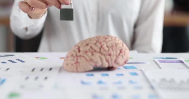 Mulher mão colocando cadeado de metal na frente do cérebro humano e documentos close-up filme 4k — Vídeo de Stock