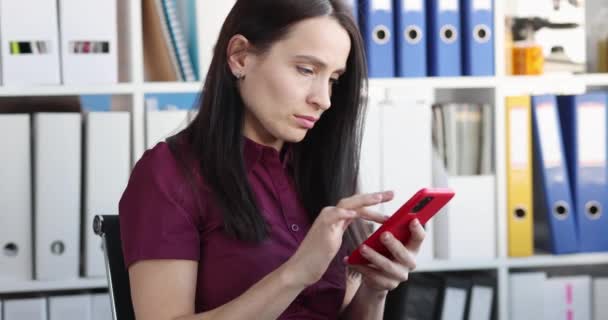 Mujer concentrada mira el teléfono inteligente y los textos primer plano — Vídeos de Stock
