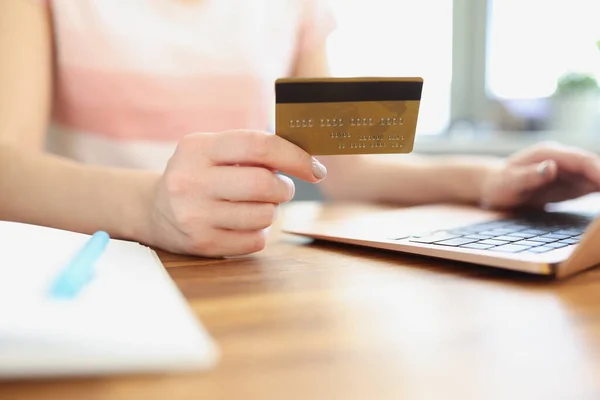 Vrouwelijke handen houden credit bank kaart in de voorkant van laptop closeup — Stockfoto