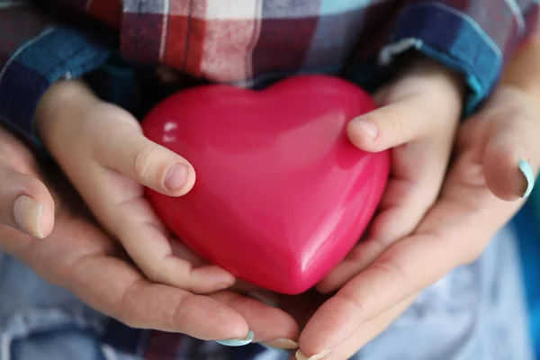Donna e bambino mani tenendo rosso giocattolo cuore primo piano — Foto Stock