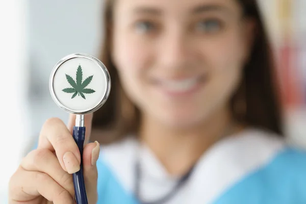 Doctor sosteniendo estetoscopio con hoja de marihuana dibujada de cerca — Foto de Stock