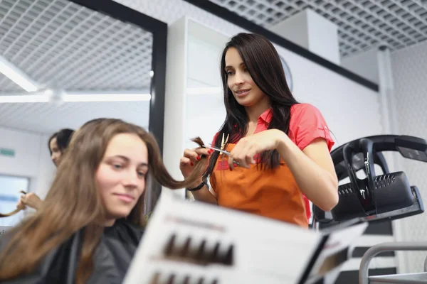 Kvinna frisör klienttips med katalog med palett av hårfärger — Stockfoto