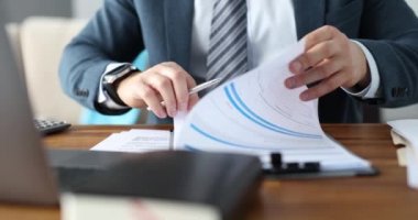 İş adamı iş belgesini işyerinde yakından inceliyor