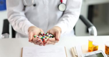 Doktor elinde bir avuç dolusu renkli ilaç tutuyor.