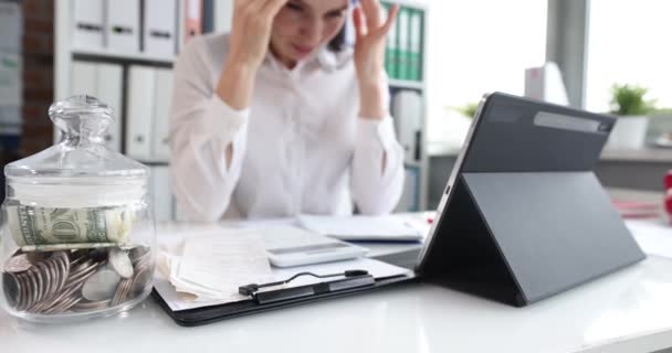 Расстроенная деловая женщина рассматривает счета крупным планом на рабочем месте — стоковое видео