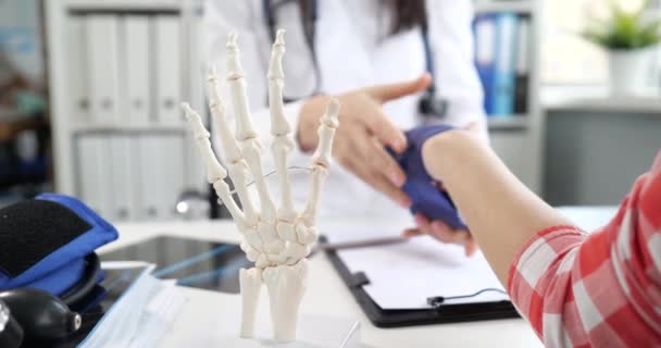 Ортопедический врач наложил эластичную повязку на перелом руки пациента — стоковое видео