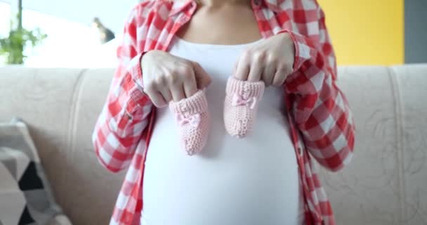 Kobieta Ciąży Trzyma Różowe Kapcie Dla Noworodka Spodziewamy Się Koncepcji — Wideo stockowe