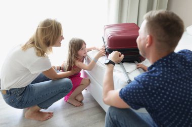 Otelde küçük bir kızla birlikte bir bavulu kapatıyorlar, yakın plan.