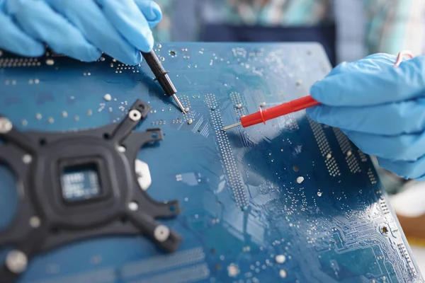 Руки з вольтметром перевіряють чип процесора — стокове фото
